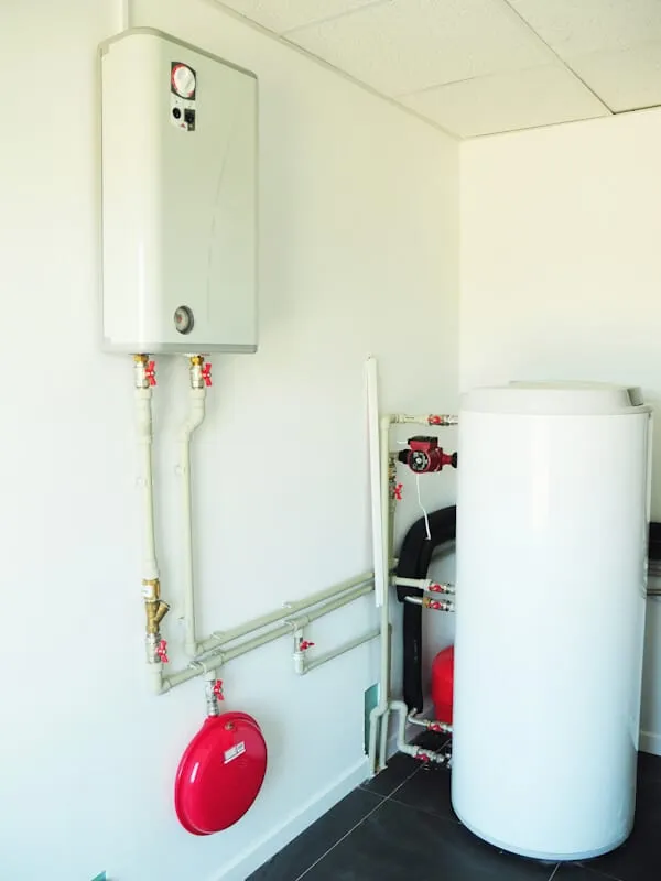 A domestic household boiler room with a new modern gas boiler, heating electric warm water system and pipes.