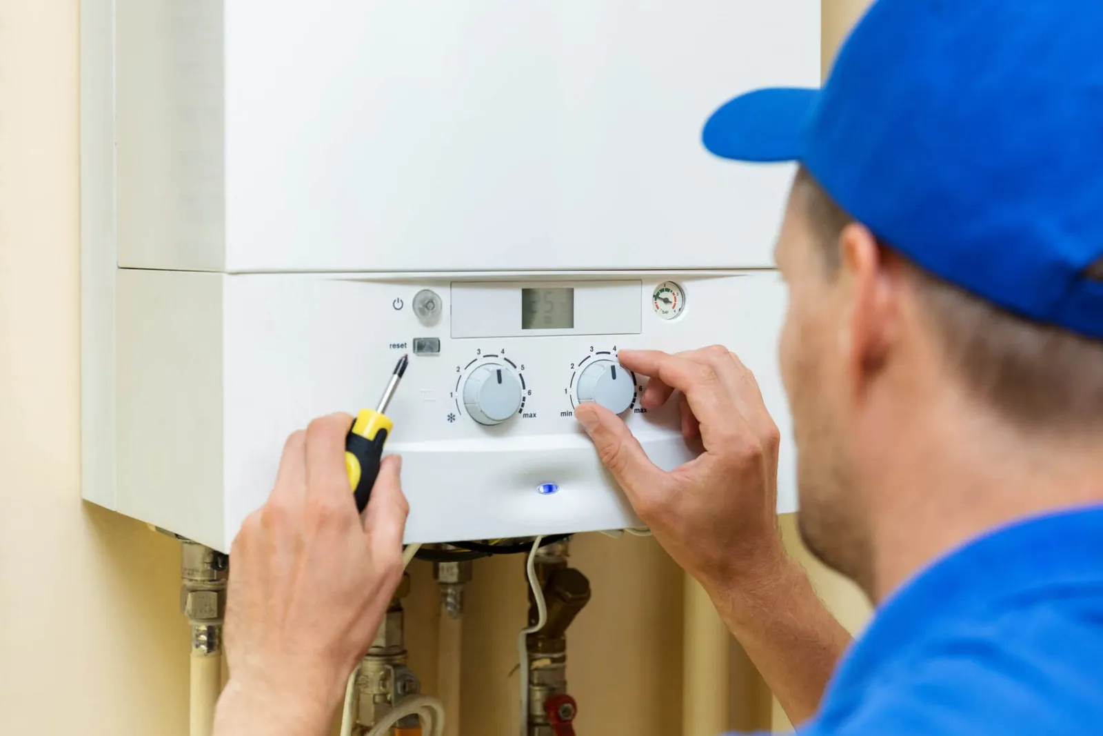 boiler installer setting up central gas heating boiler at home