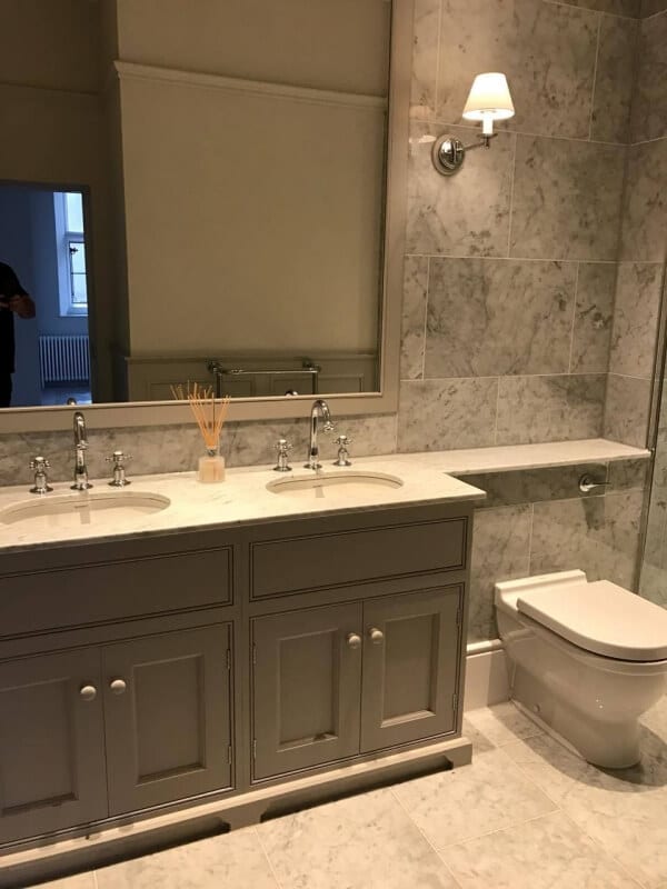 his and hers sinks with toiler, sconces and mirror